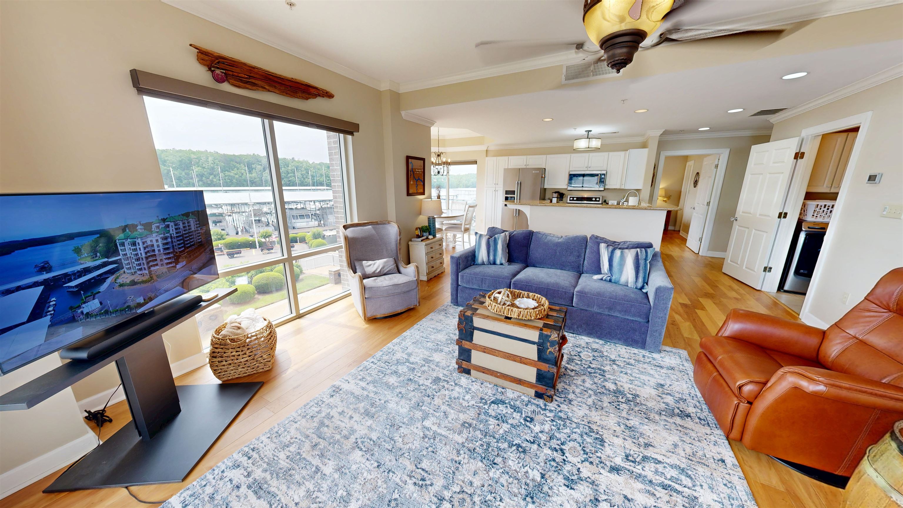 325 Cr 380 L-103 Road, Unit L103 Iuka, MS 38852 - Photo 13 of 40 Open-concept living space featuring expansive windows, wood-finish flooring, and a kitchen with white cabinetry and stainless steel appliances