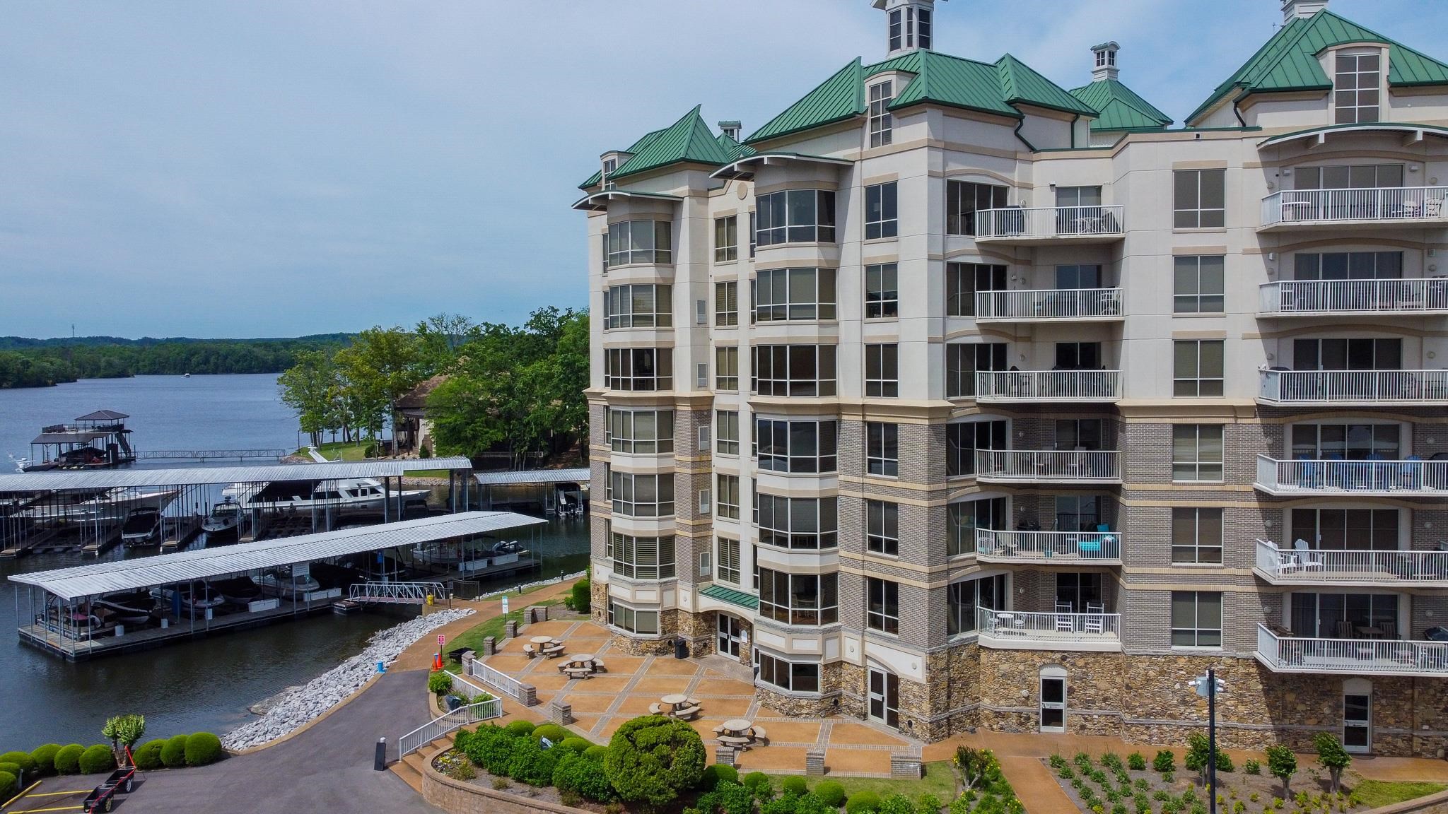 325 Cr 380 L-103 Road, Unit L103 Iuka, MS 38852 - Photo 2 of 40 Waterfront condominium building featuring multiple private balconies, a stone and stucco facade, and green hip roofs