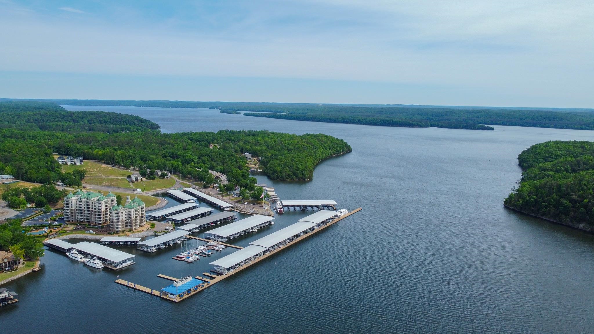 325 Cr 380 L-103 Road, Unit L103 Iuka, MS 38852 - Photo 33 of 40 Expansive waterfront property featuring a multi-story building, multiple boat docks with covered slips, and a large body of water