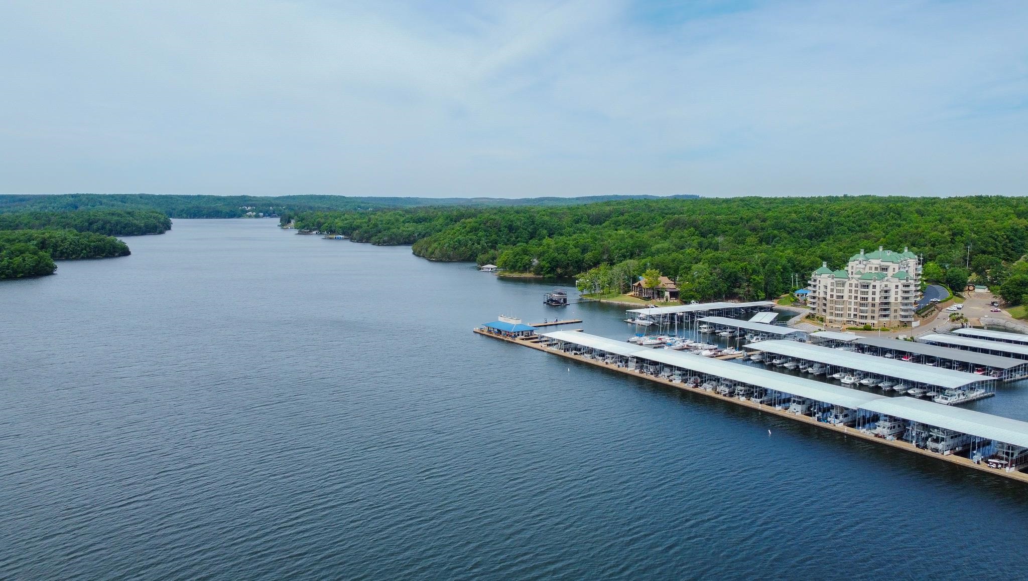 325 Cr 380 L-103 Road, Unit L103 Iuka, MS 38852 - Photo 36 of 40 Waterfront property with extensive covered boat slips, a multi-story building featuring numerous balconies, and surrounding mature tree coverage