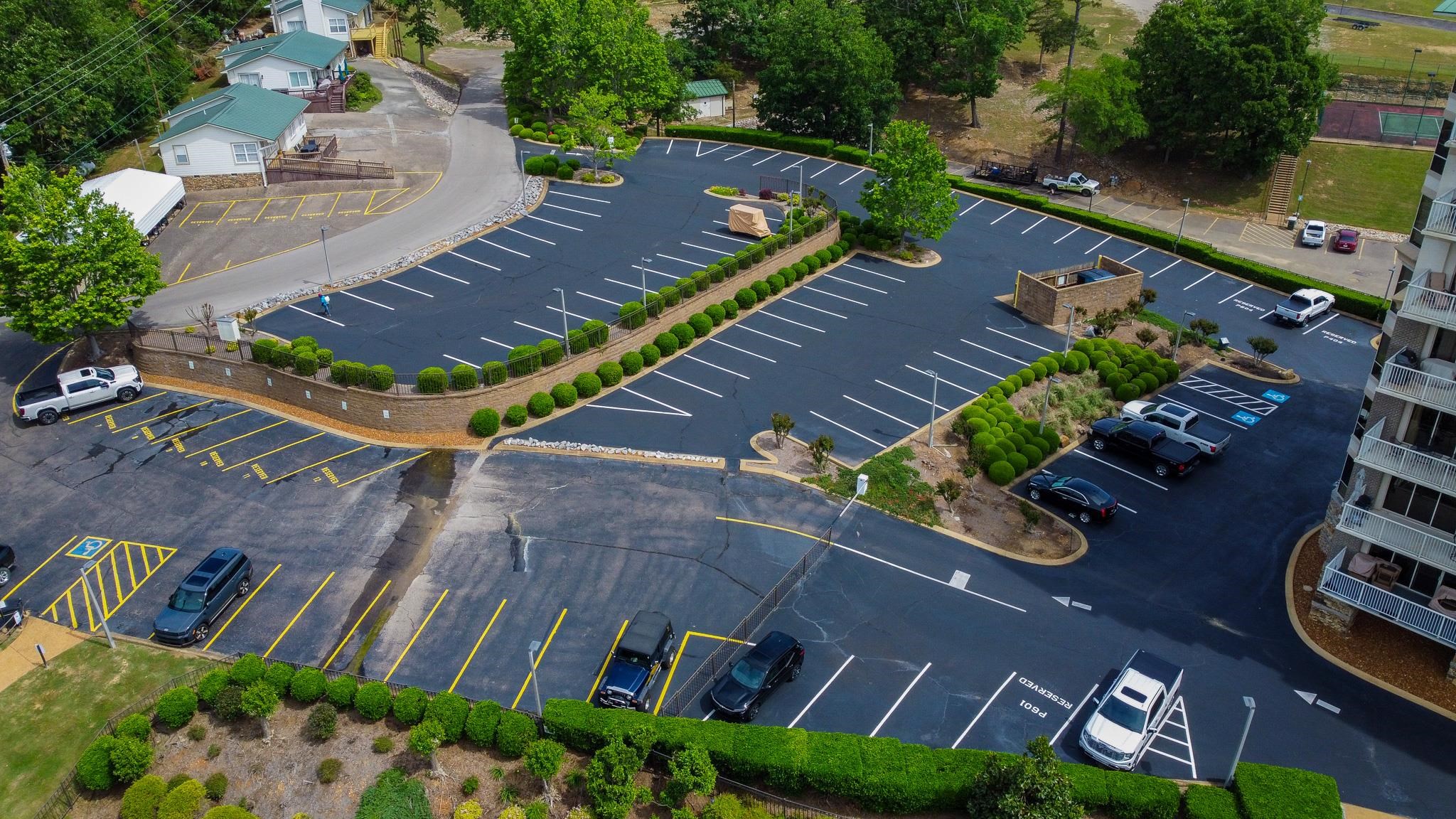 325 Cr 380 L-103 Road, Unit L103 Iuka, MS 38852 - Photo 39 of 40 Paved parking area featuring striped parking spaces, manicured shrubbery, and stone-clad retaining walls