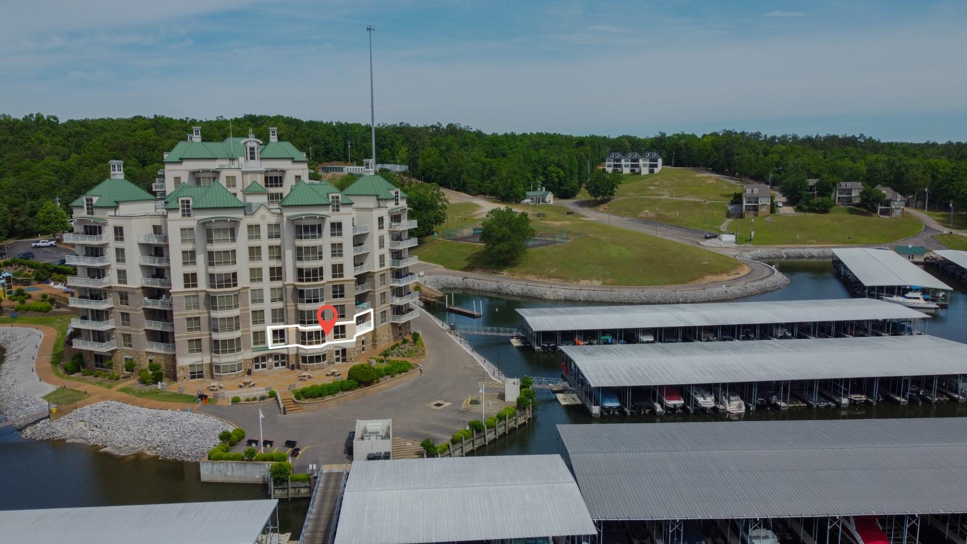 325 Cr 380 L-103 Road, Unit L103 Iuka, MS 38852 - Photo 4 of 40 Waterfront condominium building with multiple balconies, green sloped roofs, and an expansive marina