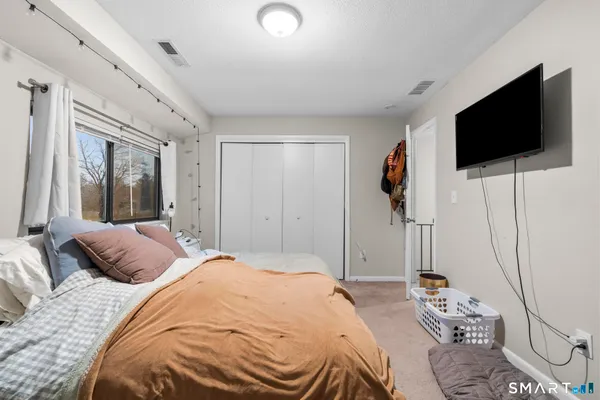 a bedroom with a bed a flat screen tv and a couch