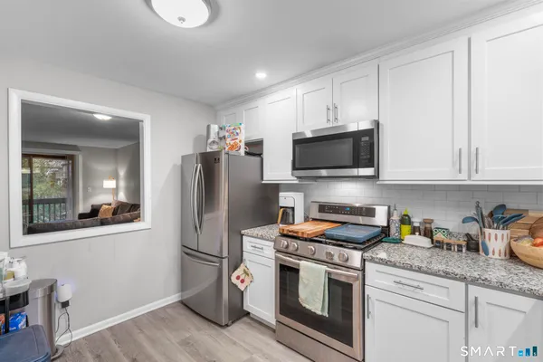 a kitchen with granite countertop a refrigerator stove and microwave