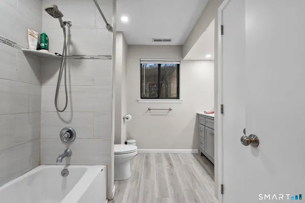 a bathroom with a sink a toilet and shower