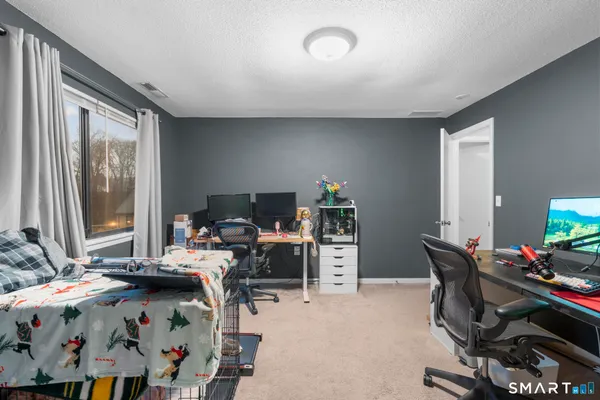 a view of a workspace with furniture and a window
