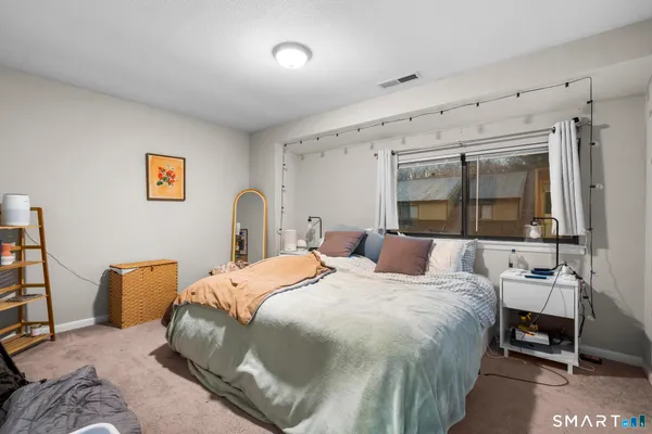 a bedroom with a bed wooden floor and window