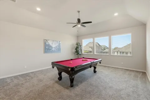 a room with pool table and windows