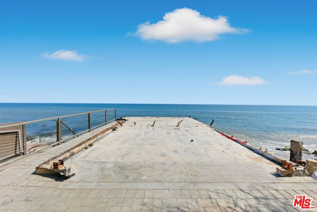 a living room with stainless steel appliances furniture and a kitchen view