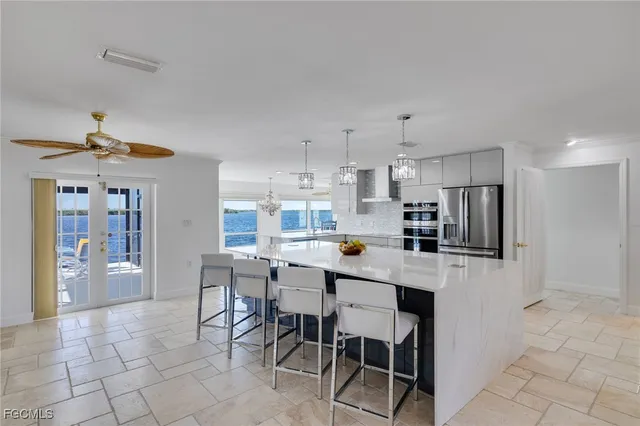 a kitchen with stainless steel appliances a table chairs refrigerator and cabinets