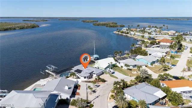 an aerial view of a house with a yard and lake view