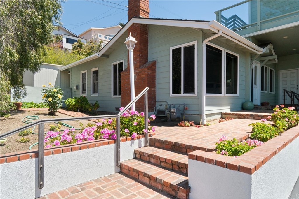 188 8th Street Cayucos, CA 93430 - Photo 2 of 33 a front view of a house with lots of flowers and trees