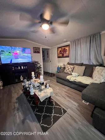 a living room with furniture a chandelier and a dining table