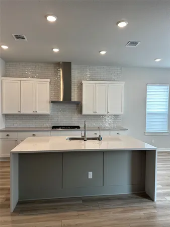 a kitchen with granite countertop white cabinets and a sink