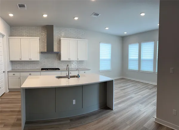 a kitchen with granite countertop a refrigerator and cabinets