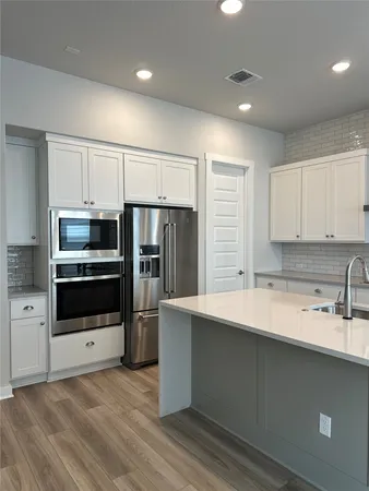 a kitchen with granite countertop white cabinets and white appliances