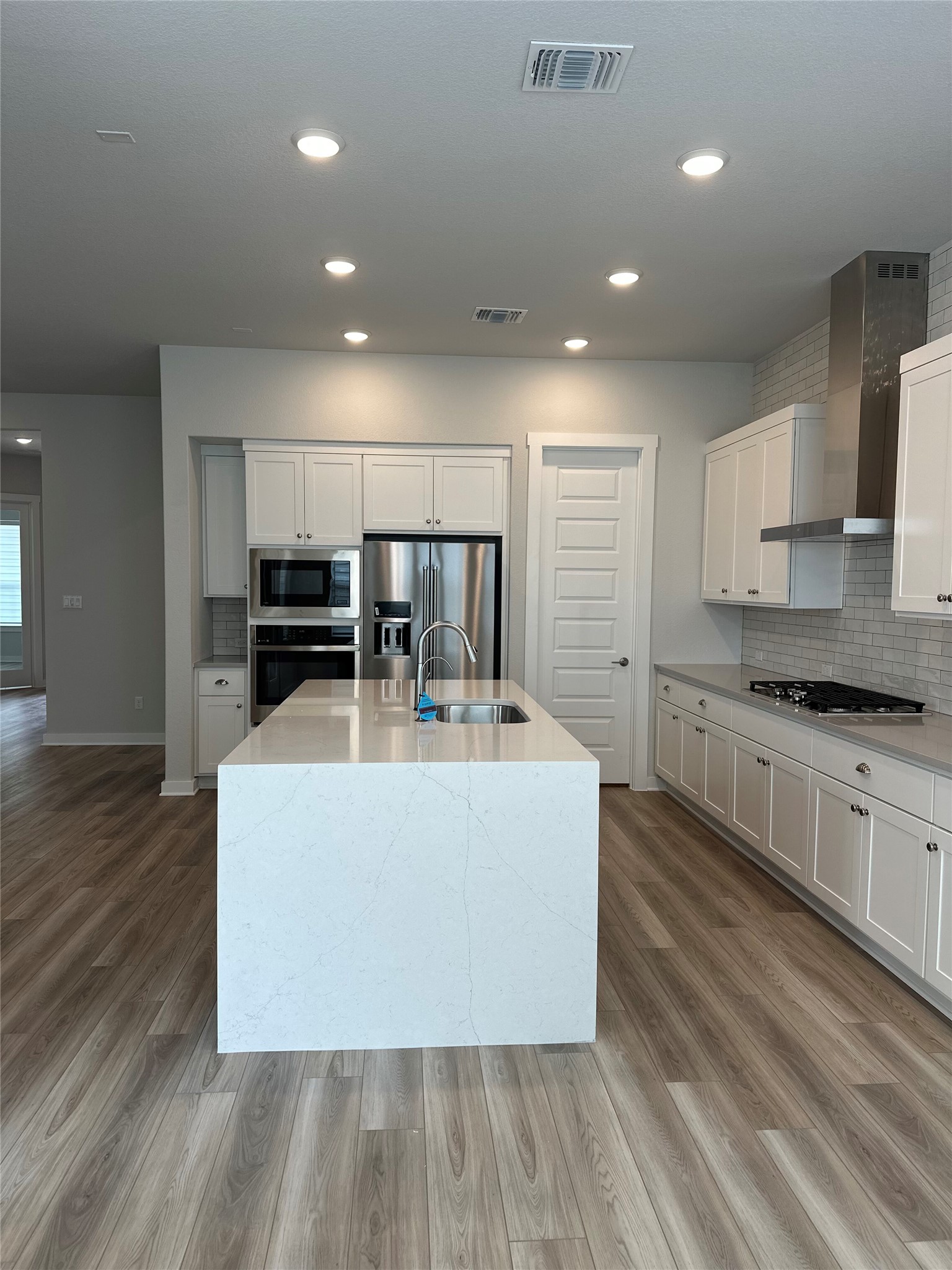 412 Lariat Loop Liberty Hill, TX 78642 - Photo 18 of 38 a large kitchen with stainless steel appliances a large counter top a stove and a refrigerator