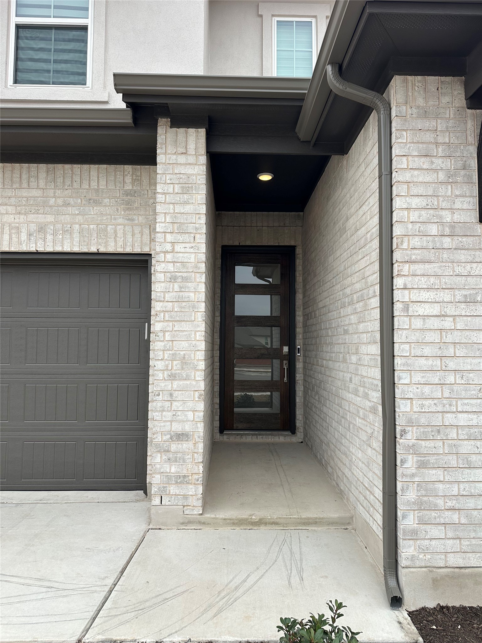 412 Lariat Loop Liberty Hill, TX 78642 - Photo 3 of 38 Doorway to property featuring a garage and brick siding