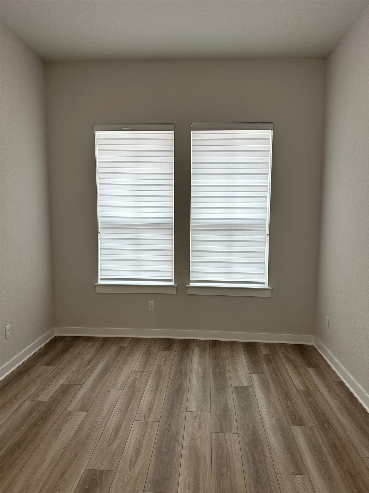 412 Lariat Loop Liberty Hill, TX 78642 - Photo 6 of 38 a view of an empty room with wooden floor and a window