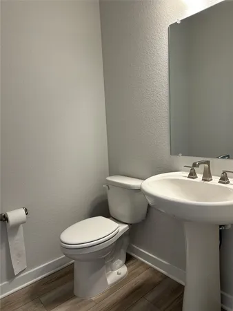 an empty room with wooden floor chandelier and windows
