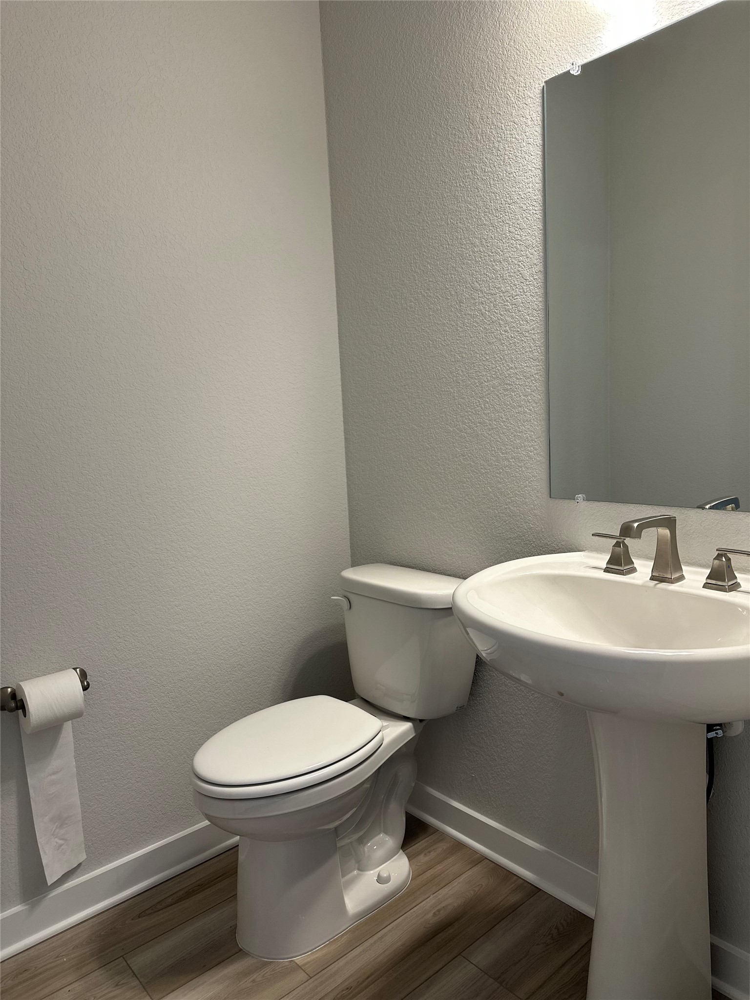 412 Lariat Loop Liberty Hill, TX 78642 - Photo 7 of 38 Half bathroom with toilet, baseboards, and wood finished floors