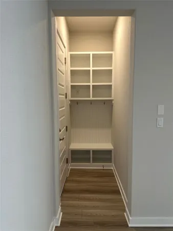 an empty room with wooden floor chandelier and windows