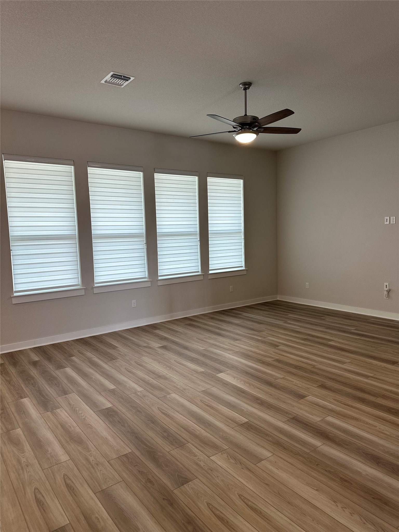 412 Lariat Loop Liberty Hill, TX 78642 - Photo 9 of 38 Spare room featuring a ceiling fan, light wood-type flooring, visible vents, and baseboards