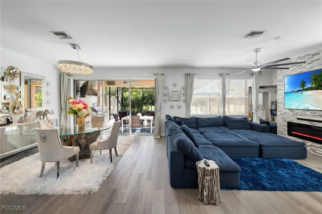 a living room with furniture a flat screen tv and kitchen view