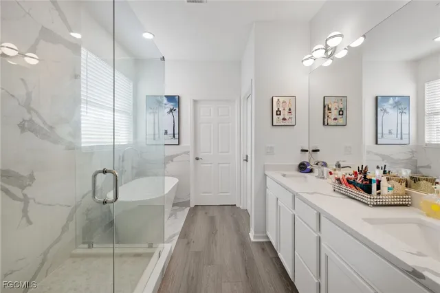 a bathroom with a sink a toilet a mirror and shower