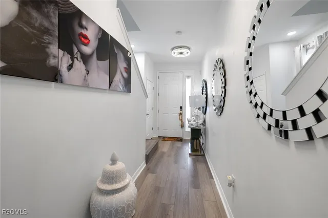 a hallway with stairs and white walls