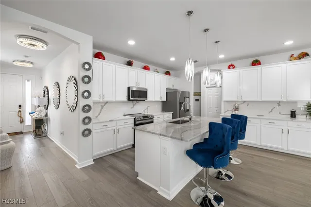a kitchen with refrigerator and chairs