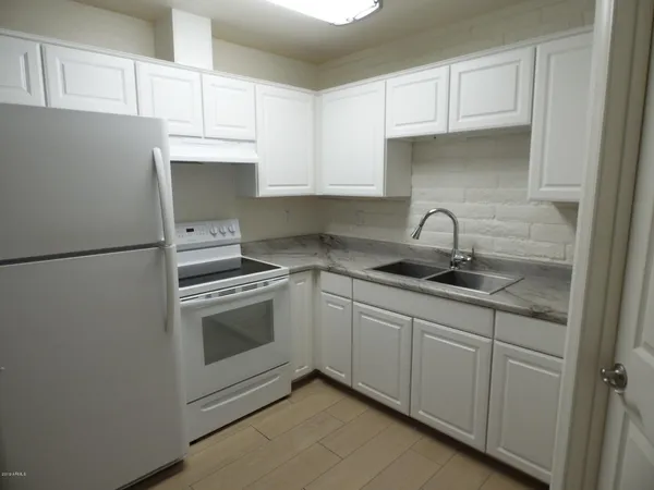 a kitchen with white cabinets and white appliances