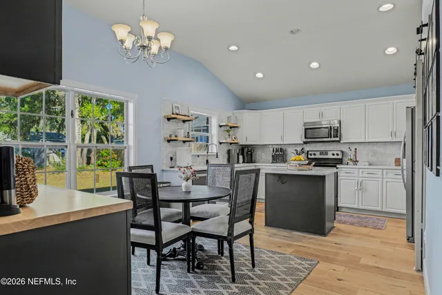 a view of a dining room with furniture a chandelier and wooden floor