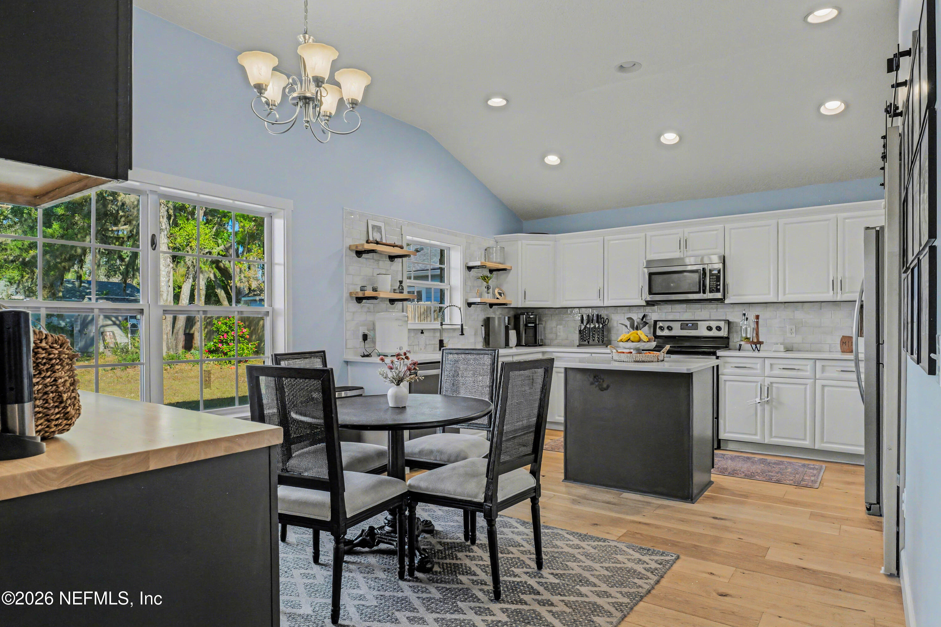 87159 Chesapeake Avenue Yulee, FL 32097 - Photo 12 of 46 a view of a dining room with furniture a chandelier and wooden floor