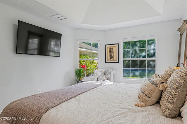 a bedroom with a bed and windows