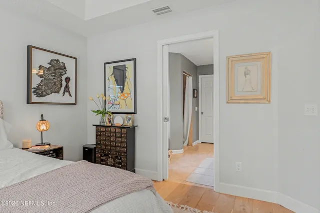 a bedroom with a bed and a painting on the wall