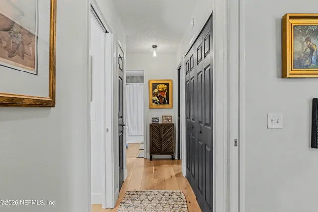 a view of a hallway with wooden floor and closet