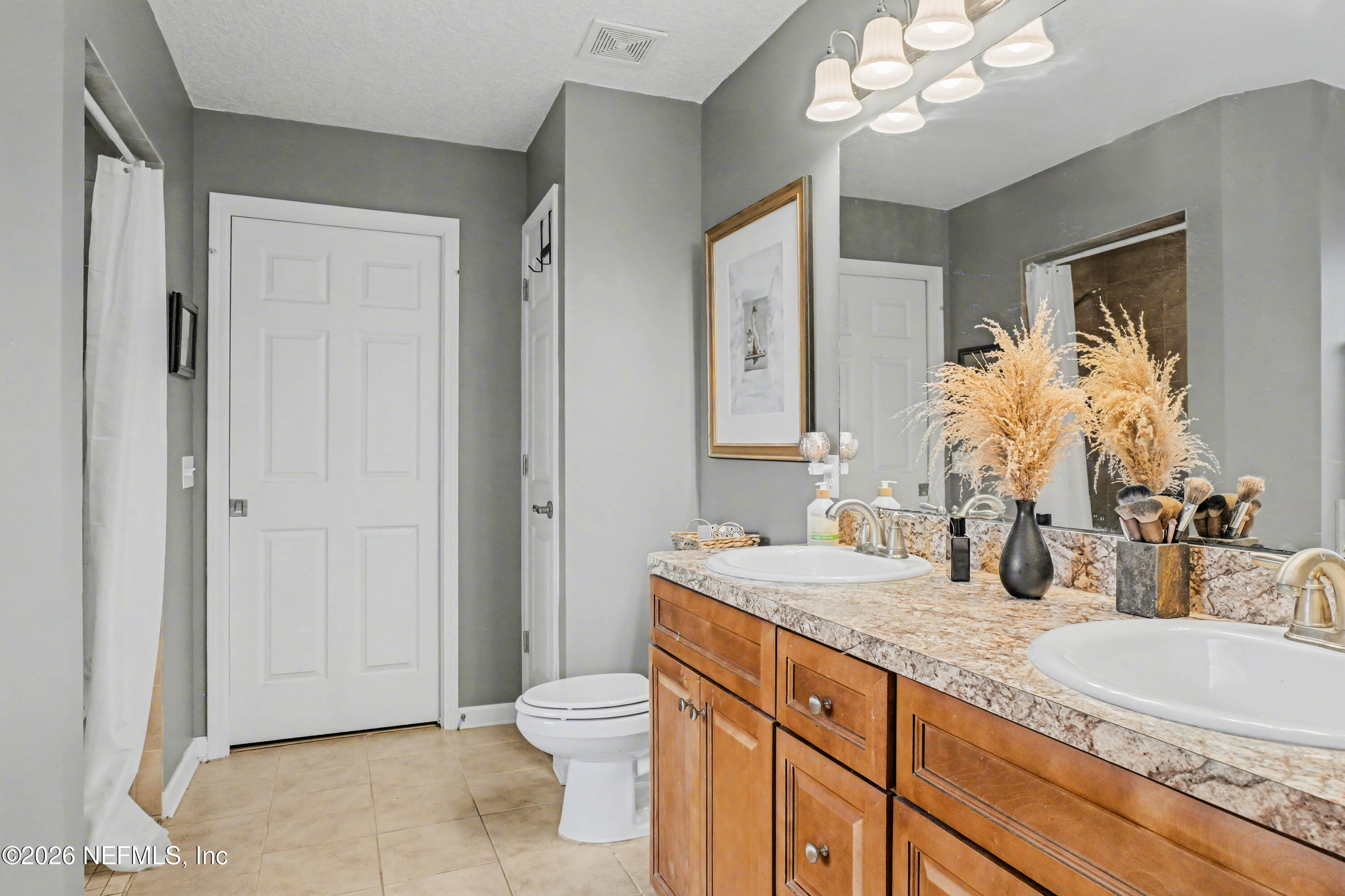 87159 Chesapeake Avenue Yulee, FL 32097 - Photo 29 of 46 a bathroom with a granite countertop double vanity sink a mirror and a toilet