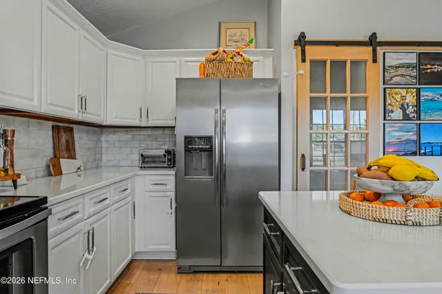 a kitchen with stainless steel appliances granite countertop a sink a stove and refrigerator