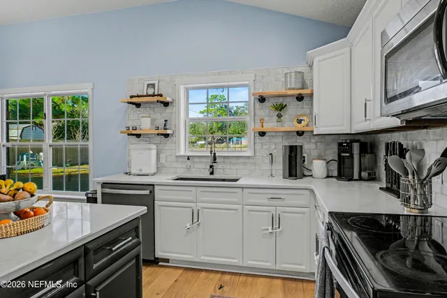 a kitchen with stainless steel appliances granite countertop a sink stove and cabinets