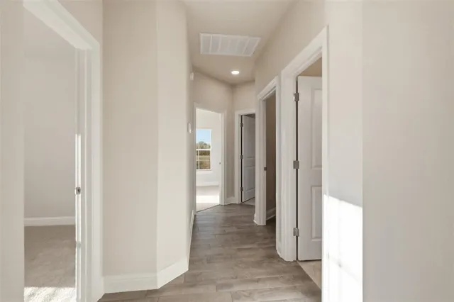 a view of a hallway with wooden floor
