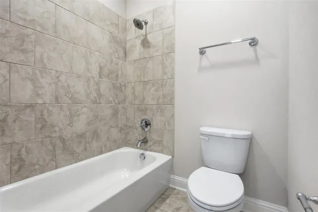 a white toilet and tub sitting next to a bathroom sink