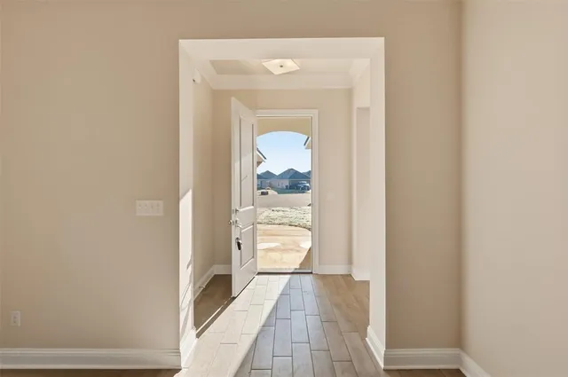a view of a hallway with wooden floor and a small living room