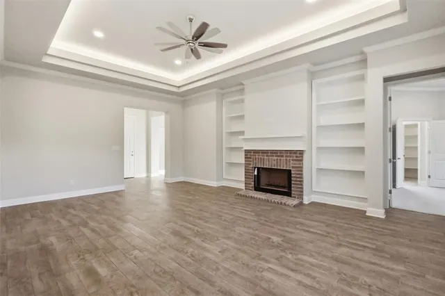 a view of an empty room with a fireplace and a window