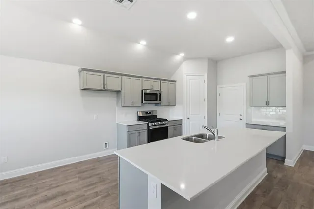 a large kitchen with kitchen island a stove a sink and a refrigerator