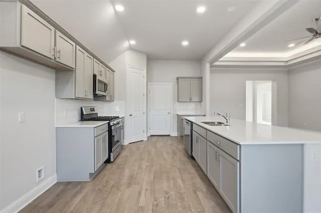 a large kitchen with stainless steel appliances sink a microwave and cabinets