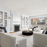 a living room with furniture large window and fireplace