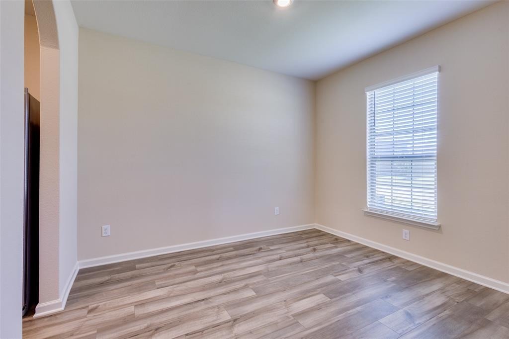 2256 Cashmere Way Princeton, TX 75407 - Photo 6 of 36 a view of an empty room with wooden floor and a window