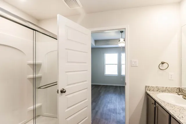 a bathroom with a granite countertop sink toilet and shower