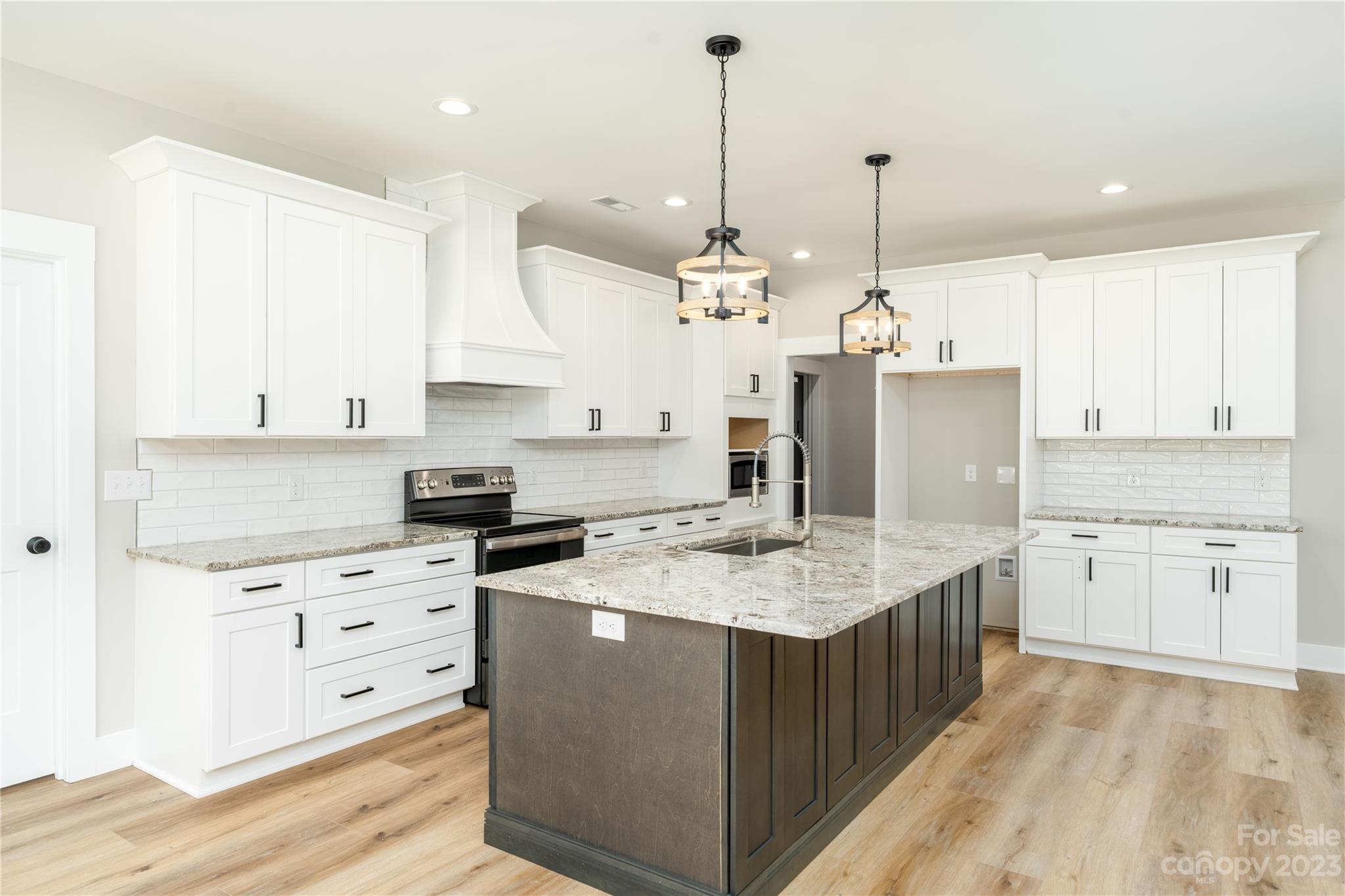2512 Shuford Road, Unit 7A Lincolnton, NC 28092 - Photo 4 of 27 a kitchen with stainless steel appliances kitchen island granite countertop a sink a stove and a wooden floors